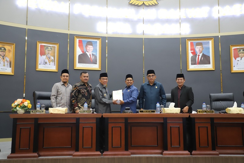 Ketua DPRD Kota Padang Muharlion menyerahkan dokumen paripurna ke Wakil Wali Kota Padang Maigus Nasir.
